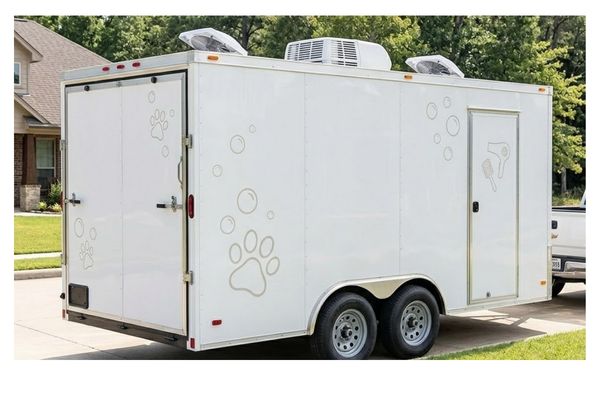 Fully enclosed white mobile pet grooming trailer without windows, featuring tasteful unbranded graphics, climate control, and a professional, private exterior, parked in a Jacksonville, TX residential area on a sunny day.